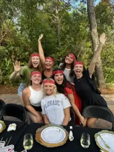Excited bachelorette group wearing headbands at outdoor hibachi dinner in Alys Beach, FL