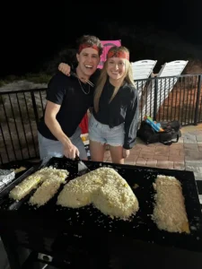 Smiling couple at nighttime hibachi dinner with rice heart art in Alys Beach, Florida