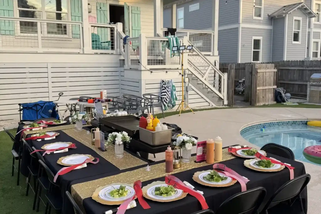 Hibachi grill and gold-decorated dinner table set up beside vacation rental pool