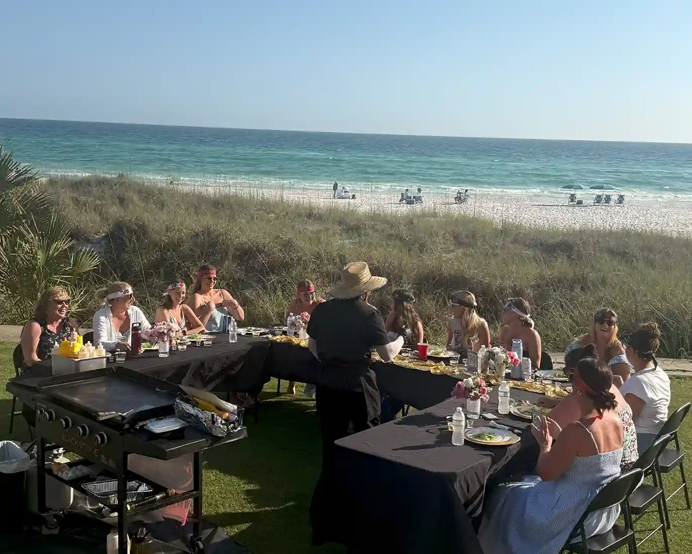 Private hibachi grill chef in 30A cooking dinner at a beach rental during sunset