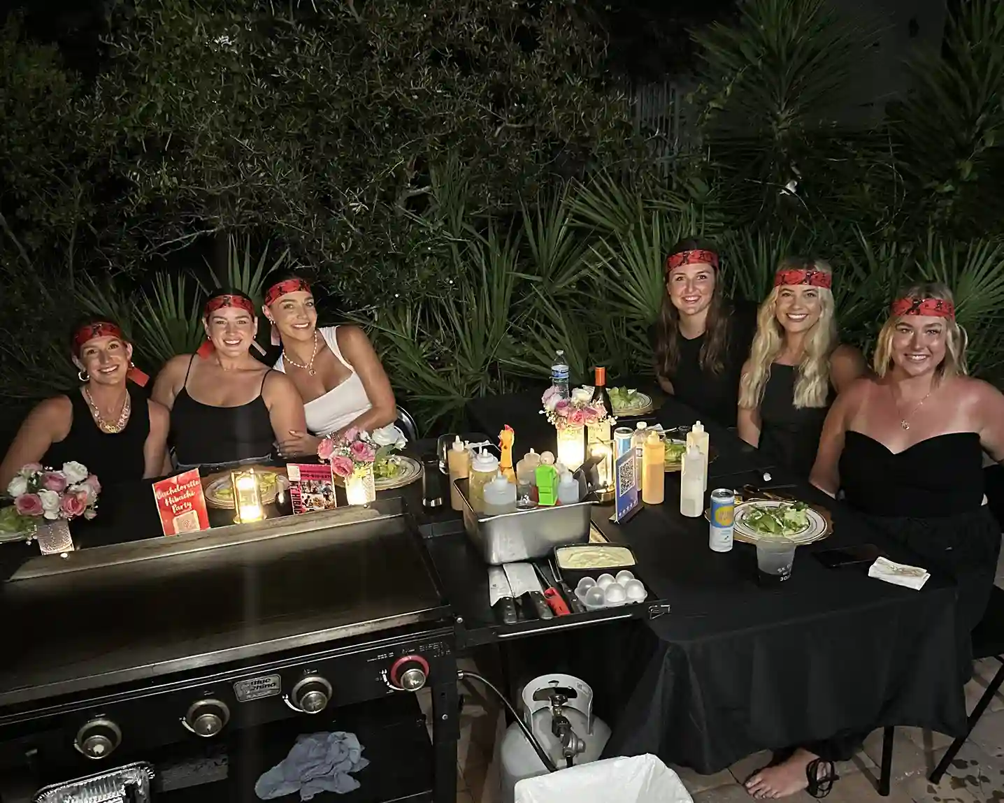 Group of women enjoying an outdoor hibachi dinner party with chef setup in 30A Florida