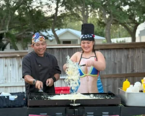 Private hibachi chef performing fire trick at home in 30A party