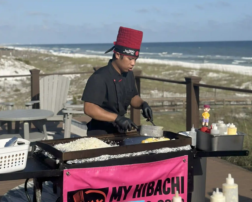 Private hibachi chef cooking by the beach at Inlet Beach with ocean view backdrop